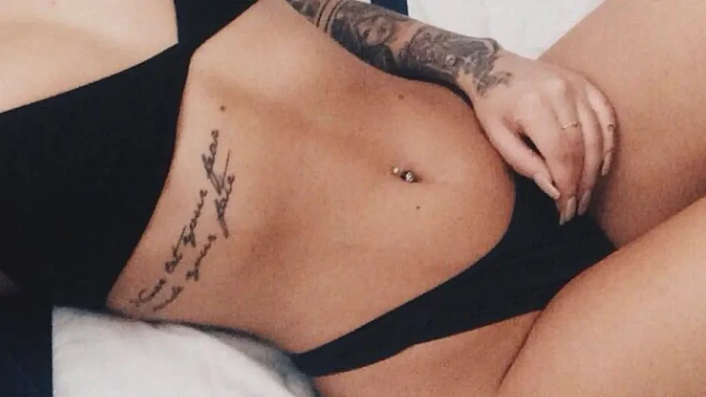 A detailed fine-line script design on a woman's ribcage, illustrating the careful balancing of size and detail in Memorial Handwriting Tattoos.