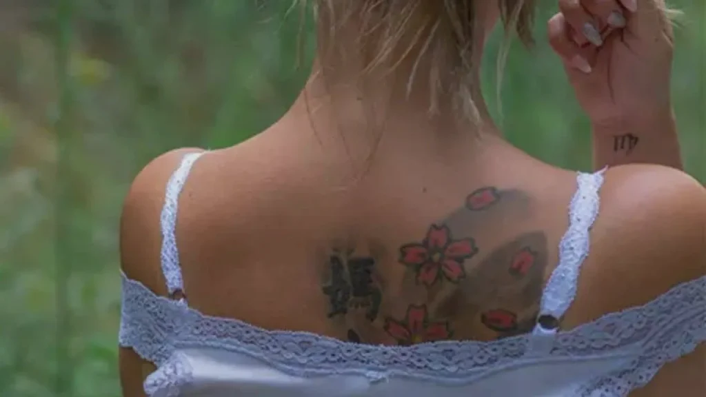 A healed back tattoo with visible ink migration, demonstrating the results of not knowing how to prevent tattoo blowout in fine-line art.