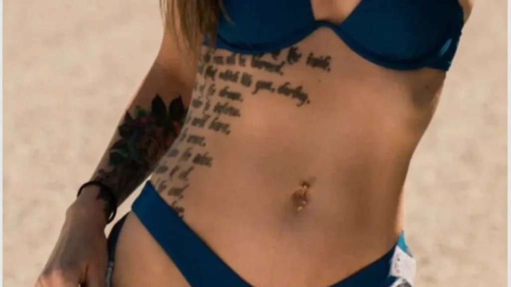 A woman showcasing a large-scale fine-line script design on her torso, demonstrating the emotional depth of Memorial Handwriting Tattoos.