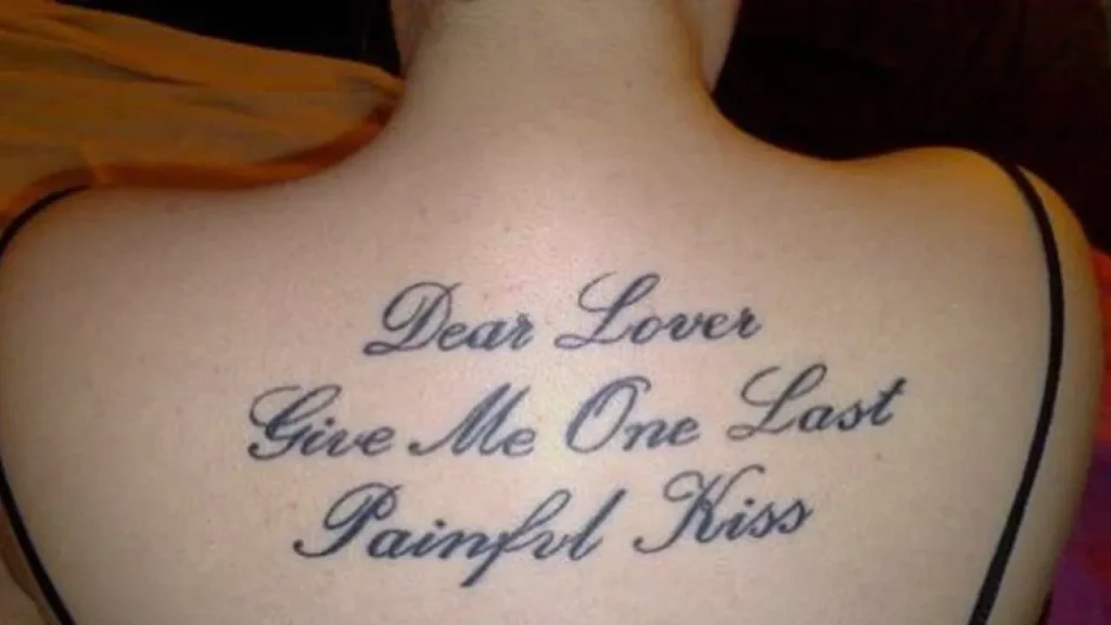 Large-scale Memorial Handwriting Tattoos featuring a cursive quote centered on the upper back.