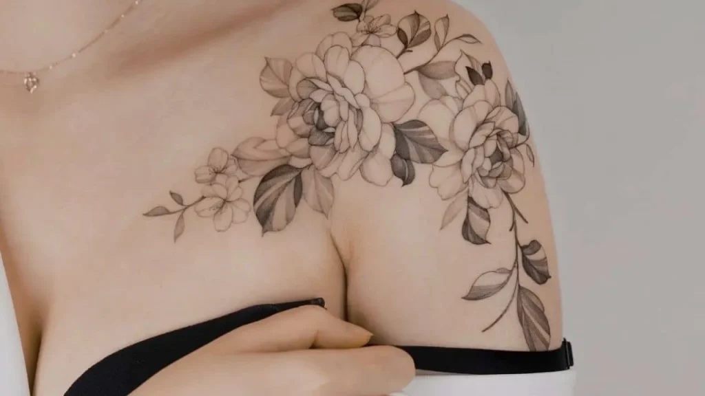 A detailed fine-line floral shoulder tattoo demonstrating successful technique and how to prevent tattoo blowout in fine-line art.