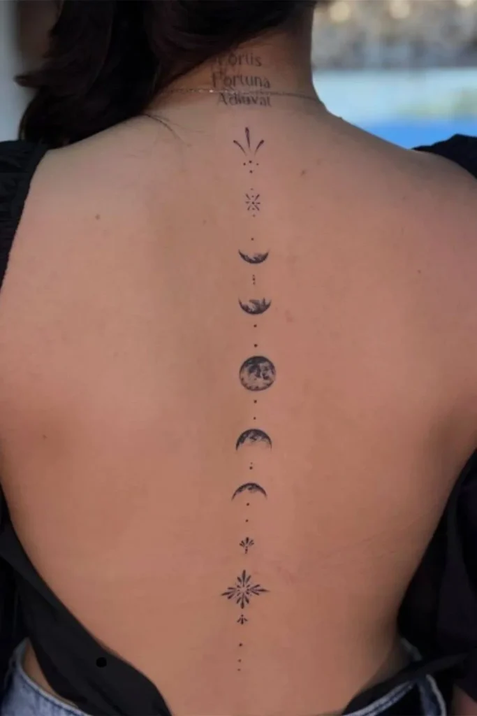 A vertical Spine Chakra Sacred Geometry Tattoo featuring detailed moon phases and minimalist celestial symbols aligned down a woman's back.