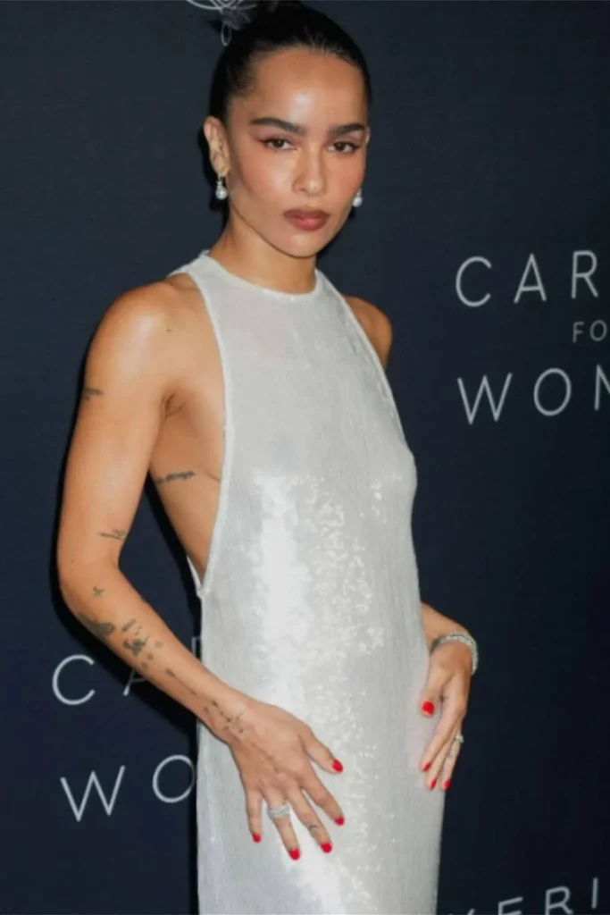 Zoe Kravitz showcasing a series of cohesive Y2K sticker sleeve tattoos and fine-line patchwork art on her arm and torso.
