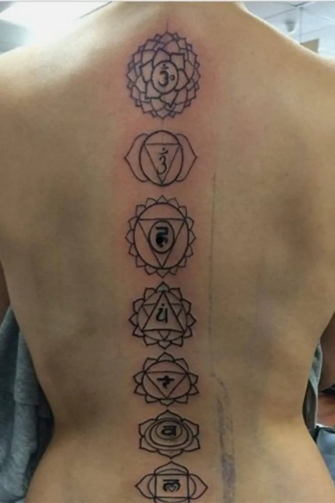 A detailed, vertical Spine Chakra Sacred Geometry Tattoo featuring seven bold black-ink symbols from the crown to the lower back.